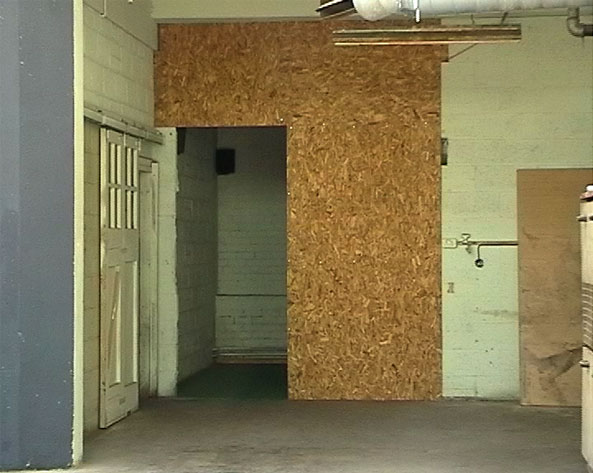 Image of doorway construcded out of chip board - entrance to Transfix installation